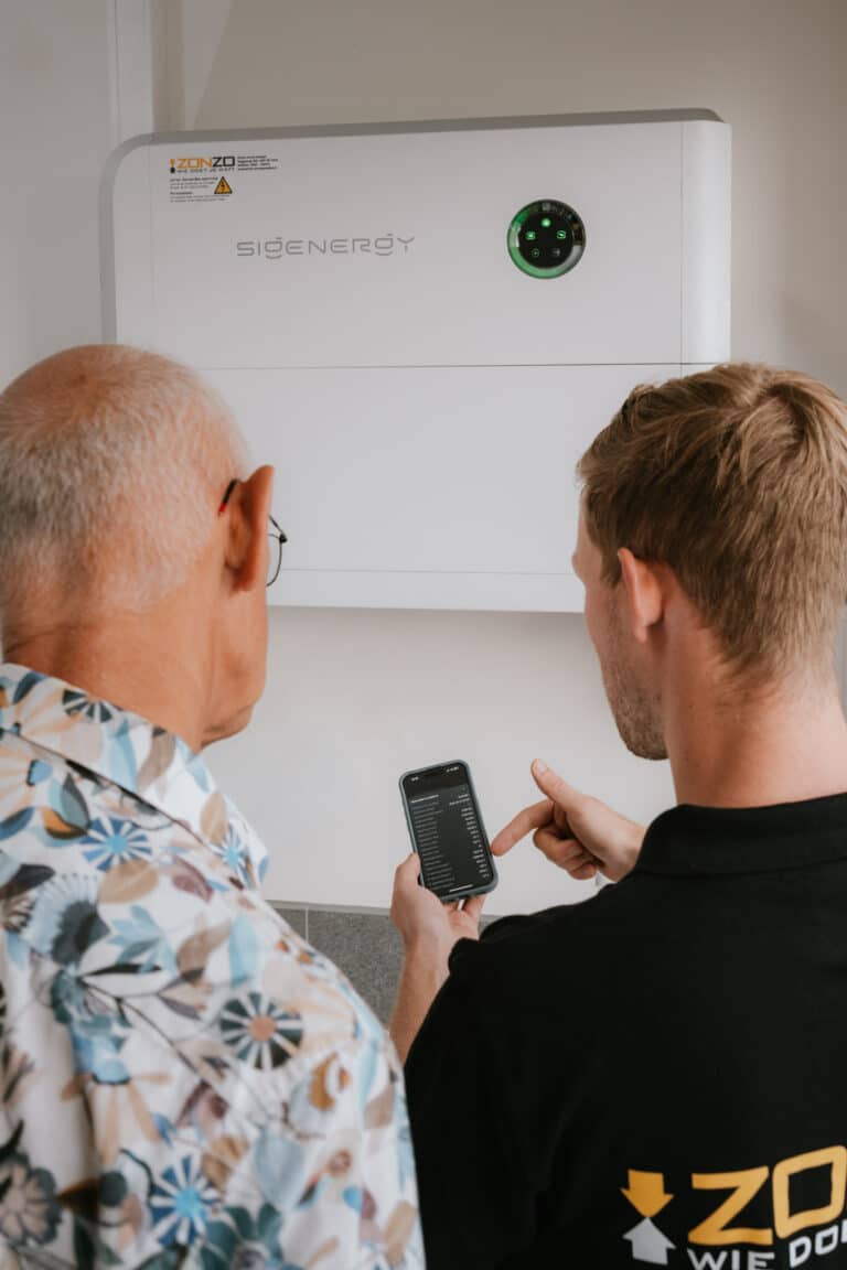 Zonzo klant krijgt uitleg over zijn thuisbatterij en de werking van de energiebeheer van het display op zijn telefoon om zijn energiekosten te dekken