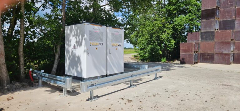 Zakelijke energieopslag bestaand uit twee modules die geplaatst zijn achter een vangrail bij een agrarisch bedrijf in Oostwoud.