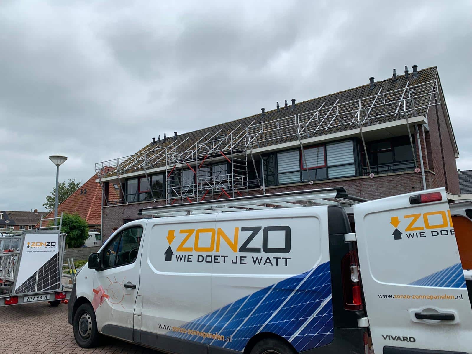 Een zonzo bus met open deur. op de achtergrond staat een dak met bevestigingsmaterialen en dakbeveiliging